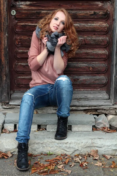 Een jonge vrouw met een sjaal voor een oud huis — Stockfoto