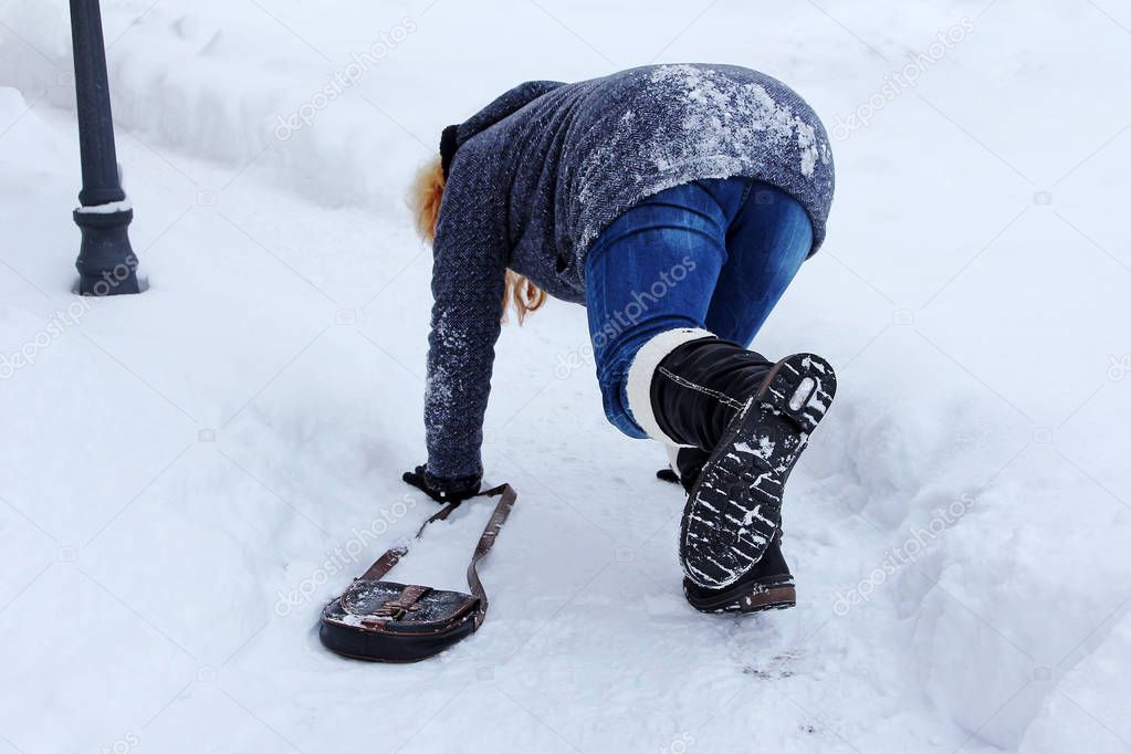 A woman slipped and fell on the winter road. Fall on slippery roads