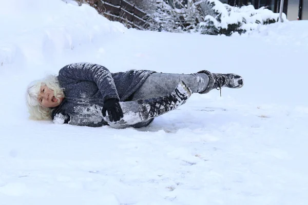 女性の冬の道路の上で滑って落ちたダウンと痛い自分 滑りやすい路面に落ちる — ストック写真