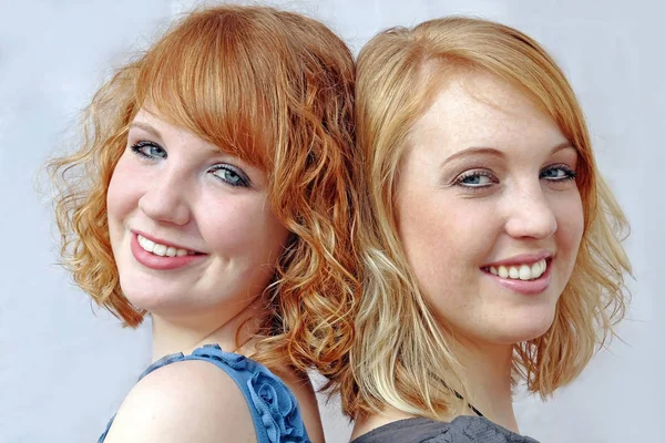 Pretty young red-haired laughing sisters. Happily laughing sisters