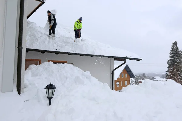 Δύο Άνδρες Φτυαρίζουν Βαρύ Χιόνι Από Μια Στέγη Σπιτιού — Φωτογραφία Αρχείου