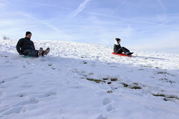 一男一女骑着雪地摩托下山 — 图库照片