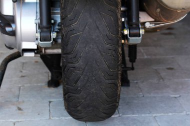 A worn tire on a motorcycle is dangerous clipart