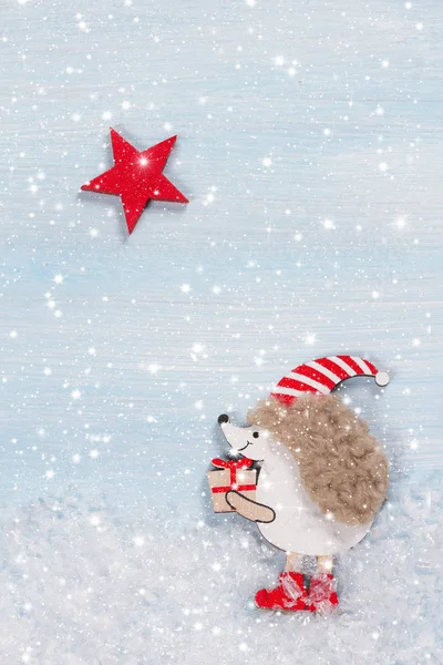 Cartão de Natal com um ouriço em um fundo de madeira . — Fotografia de Stock