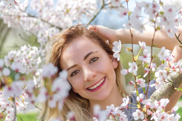 Bella giovane donna felice in un giardino fiorito primaverile — Foto Stock