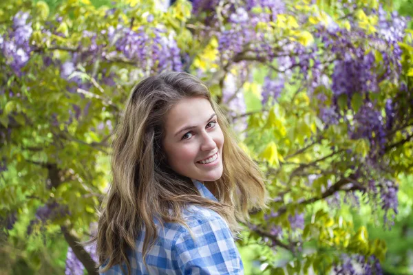 Primavera bellezza ragazza all'aperto. Fioritura albero di glicine . — Foto Stock