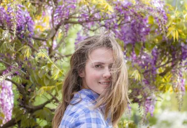 春天的美丽女孩在户外。盛开的紫藤树. — 图库照片