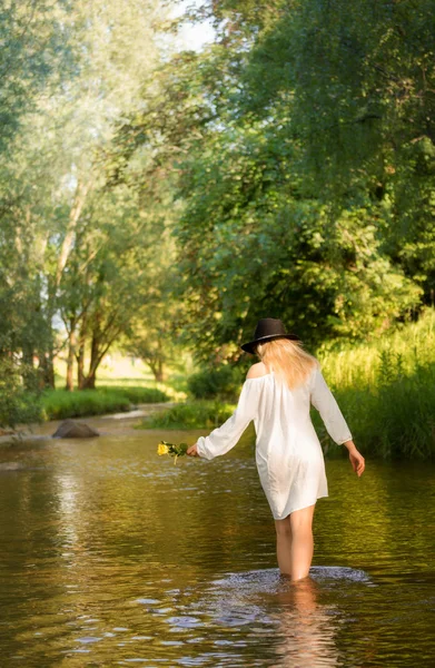 Mujer joven en el vestido blanco en medio de un arroyo .. — Foto de Stock