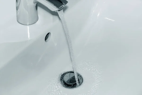 Agua corriente desde el grifo hasta el lavabo —  Fotos de Stock