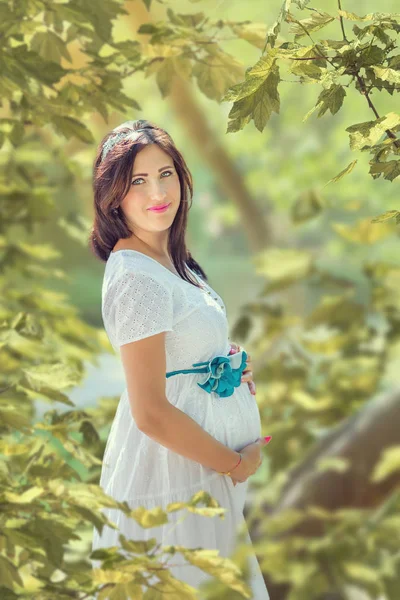 Portret kobiety w ciąży na tle liści — Zdjęcie stockowe