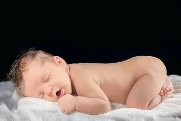 Portret van een pasgeboren baby op een zwarte achtergrond — Stockfoto