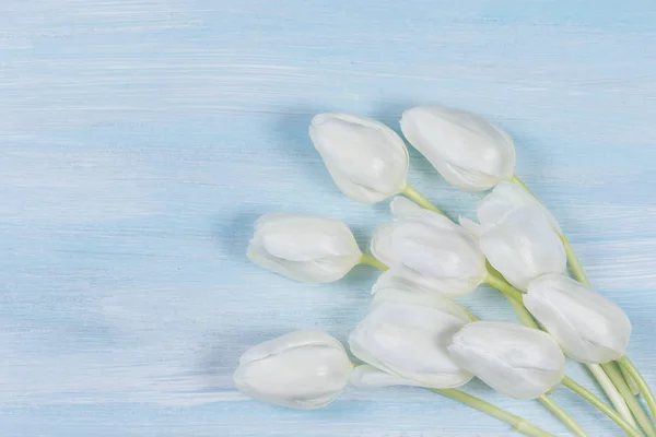 Weiße Tulpen auf einem Holztisch. Ansicht von oben. — Stockfoto