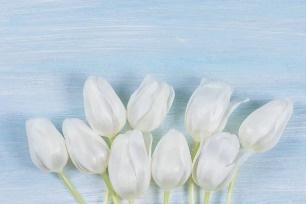 Tulipanes blancos sobre una mesa de madera. Vista superior . —  Fotos de Stock