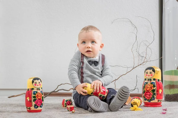 Küçük çocuk ile Rus iç içe geçmiş oyuncak bebek oyun — Stok fotoğraf