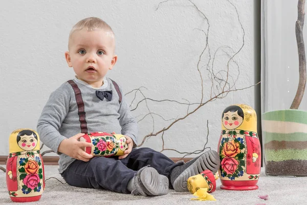 O menino brinca com a boneca russa aninhada — Fotografia de Stock