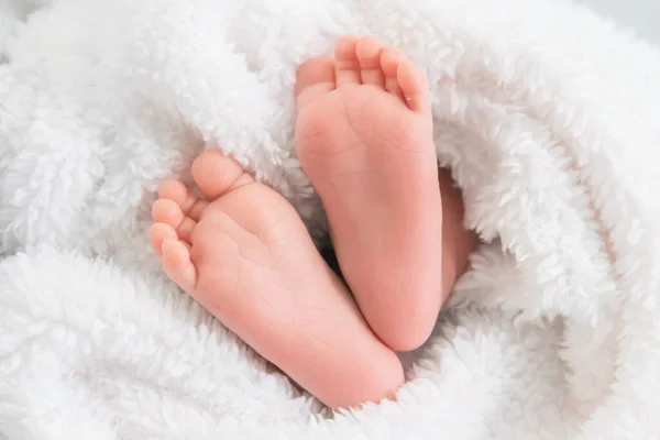 Bebé pies en la bata blanca . — Foto de Stock