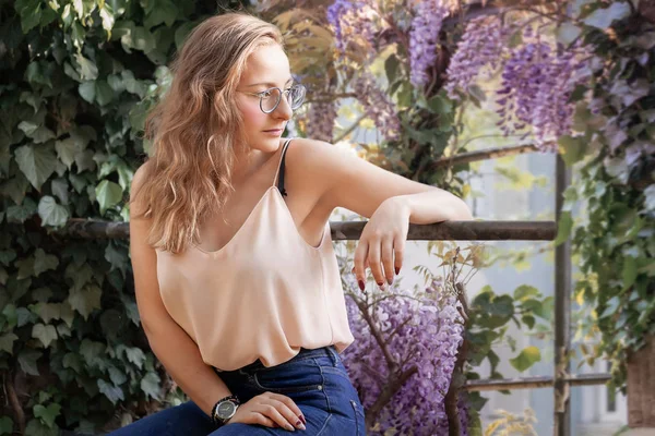 Mujer joven posando con flores de glicina —  Fotos de Stock