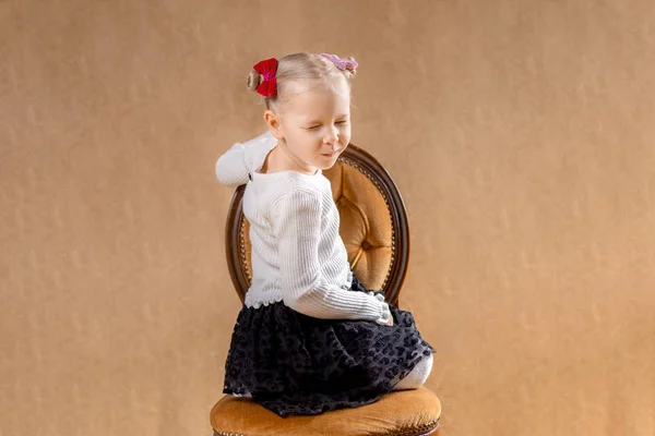 小女孩坐在演播室的椅子上 — 图库照片