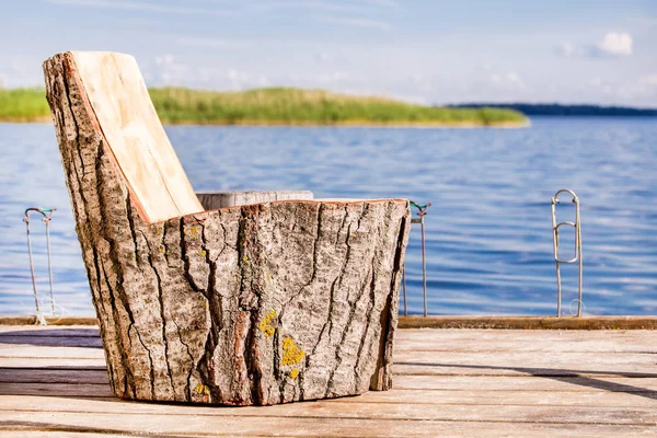 Silla de madera hecha de tocón grande en un muelle de pesca en el lago o el río — Foto de Stock