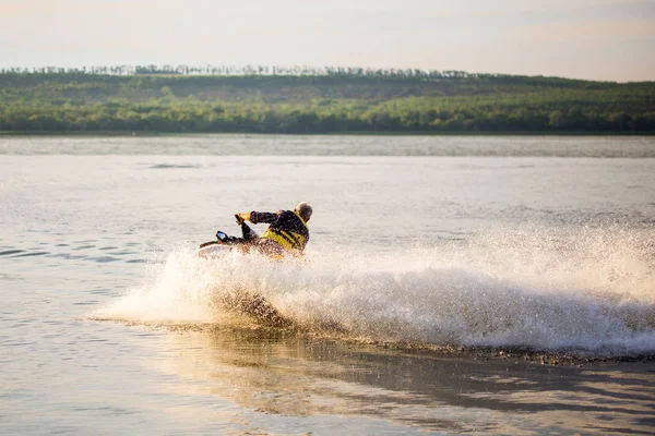 Un homme conduisant un jet ski, rabougrissant et faisant des gouttes d'eau — Photo