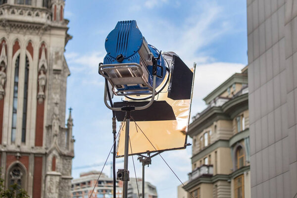 Большой профессиональный яркий прожектор с цветным фильтром на штативе
