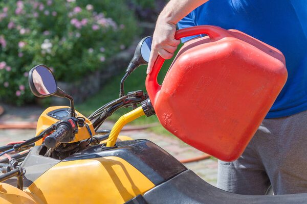 Caucasian man in sport protective goggles holds red canister and