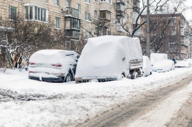 Büyük kar tabakası ile kaplı bir sokakta araba.