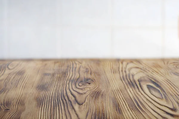 Emty claro envejecido mesa de madera marrón para la colocación del producto. Kithen rústica mesa rural para la comida. Azulejo de celda borrosa blanca en el fondo —  Fotos de Stock