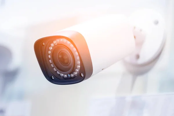 Große weiße professionelle Überwachungskamera. cctv an der Decke montiert. LED-Lampen um die Linse. Sicherheitskonzept. Kopierraum, neutraler hellblauer Hintergrund — Stockfoto