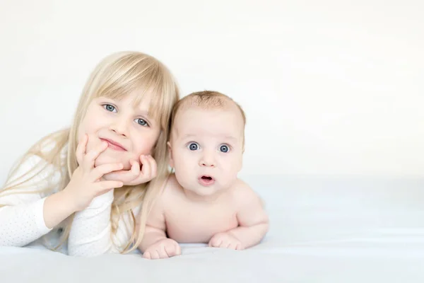 Retrato de irmão e irmã. Duas crianças giras deitadas na cama. Expressão surpreso ou surpreso de olhos abertos. Irmão e irmã melhores amigos, família feliz e conceito de infância — Fotografia de Stock