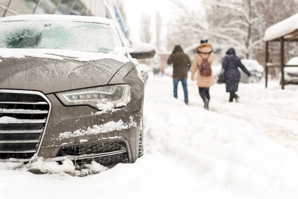 Auto geparkeerd in sneeuwjacht bij city straat. Zware winter sneeuwval. Mensen lopen terwijl sterke sneeuw en wind. Sneeuwstorm van de Storm — Stockfoto
