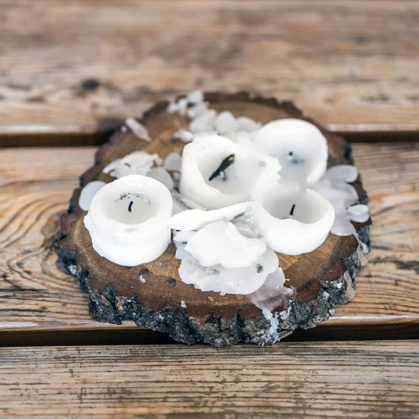 Burnt candles with melted wax on a wooden table — Stock Photo, Image
