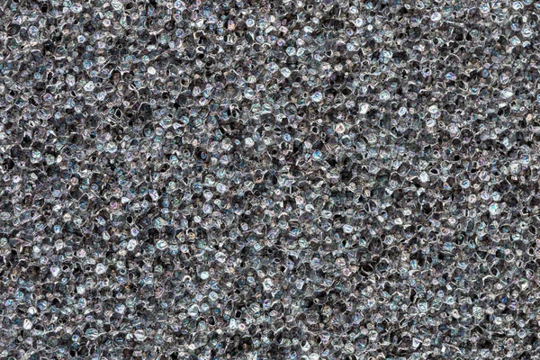 Textura de espuma de poliuretano negro de primer plano. Bengalas de película de arco iris. Fondo celular negro abstracto —  Fotos de Stock