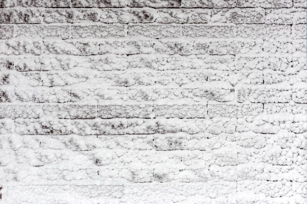 Brick wall covered with snow. Iced winter surface texture.  Copyspace for product placement or text