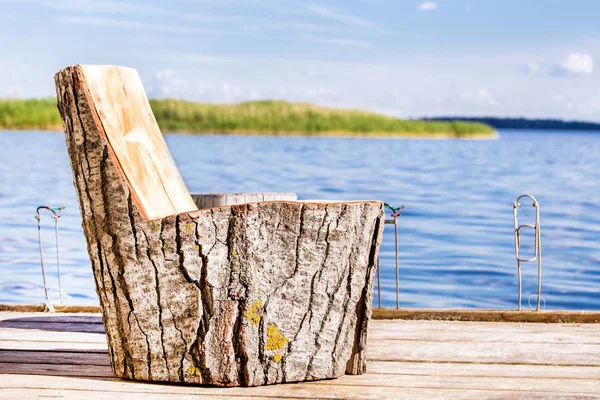 Silla de madera hecha de tocón grande en un muelle de pesca en el lago o el río — Foto de Stock