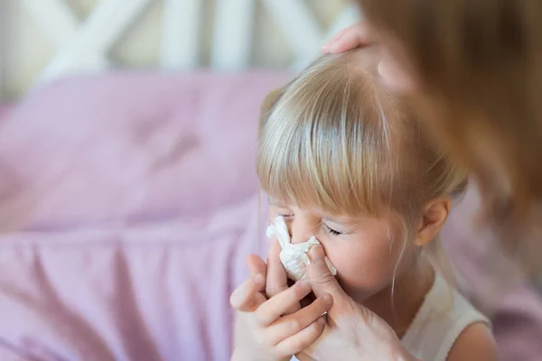 Barn med rinnande näsa. Mamma hjälper till att blåsa barnens näsa med papper. Säsongsöppen sjukdom — Stockfoto