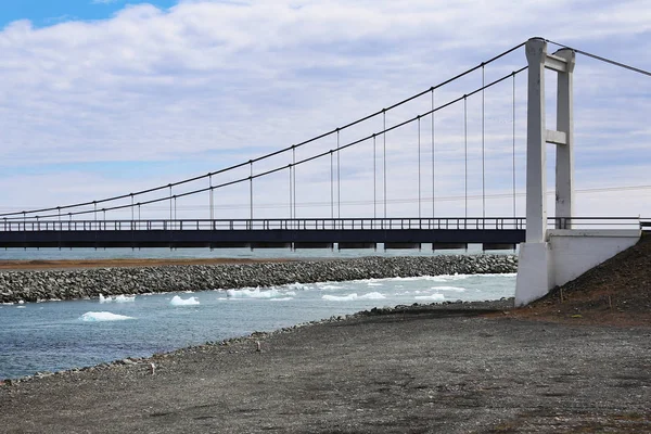 Melting ice on river floating under bridge. Spring season ice drift, high water and drift