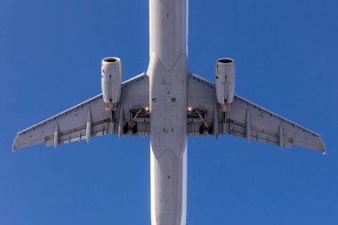 Yakın çekim alt görünümü büyük yolcu uçağı. Arka plan üzerine açık mavi gökyüzü