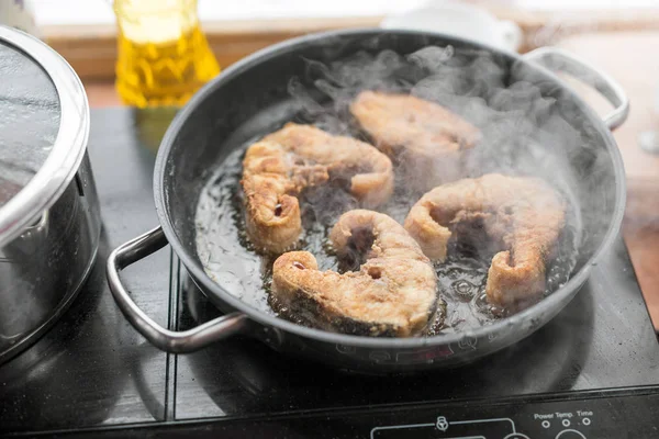 Pan with frying sturgeon fish. Outdoor kitchen. Summer barbeque and vacation