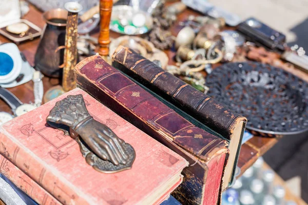 Rommelmarkt de teller. Oude vintage leeftijd boeken, bronzen deur knocker en andere retro goederen op de swap meet — Stockfoto