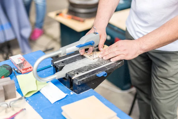 Jig ile çalışan adam gördüm. Fretsaw aracı sabit tablo üzerinde sabit. Ahşap figürler ile elektrik yapmak kişi araç gördüm — Stok fotoğraf