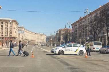 Kiev,Ukraine - May 06, 2017:Central street of ukrainian capital Kyiv Khreschatyk closed for traffic by police car and officer. Pedestrian area in centre. Toursist walking by crosswalk clipart