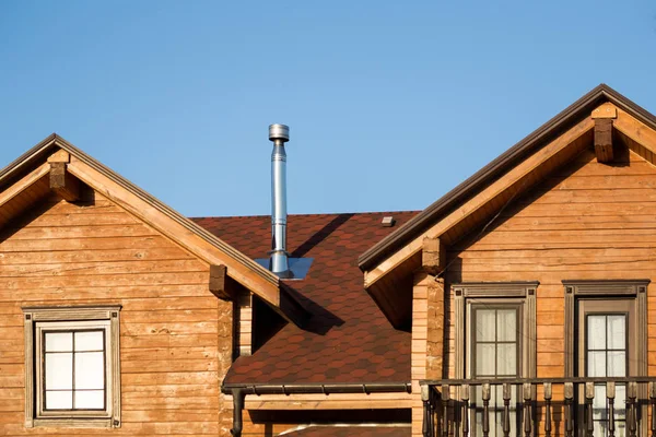 Součástí moderní dřevěný venkovský dům s modrou oblohou na pozadí. Střecha eco rezidenční budova v blízkosti lesa. Architektuře kolibou a — Stock fotografie
