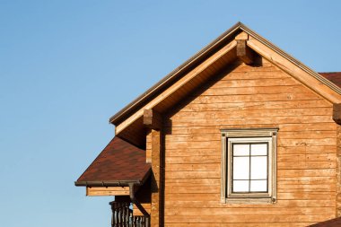Modern ahşap kır evi zemin üzerine mavi gökyüzü ile bir parçası. Çevre orman bina konut çatısı. Bina ve rustik chalet mimarisi