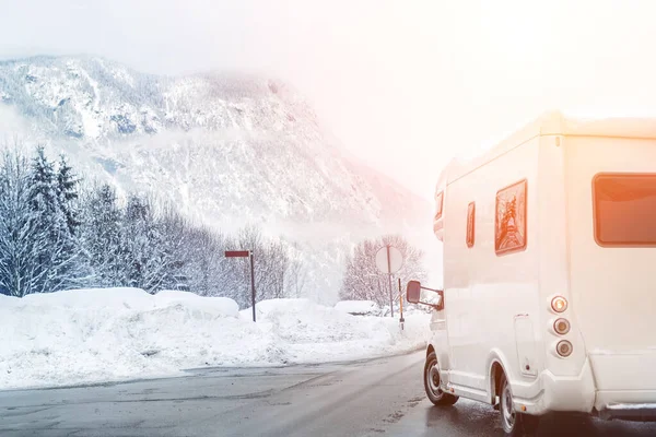 Kış dağı yolu manzarası. Kamp aracı yana dönüyor. Aile seyahati, karavanda tatil gezisi. Güzel Avusturyalı doğa sahnesi
