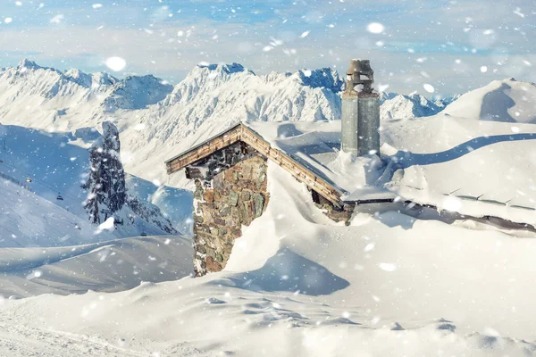 Scenic Highland alpesi régi elhagyatott kő kunyhó kémény hótakaró vastag hótakaró után hóvihar. Hegyi rusztikus menedék épület táj fényes napos napon — Stock Fotó