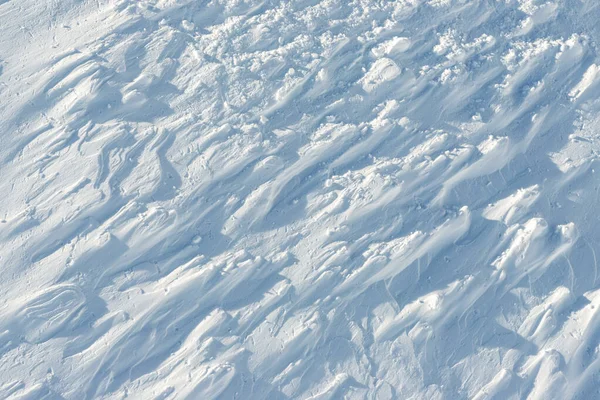 Snowy abstract off-piste skiing backround with ski and snowboard trails and tracks on new virgin powder snow. morning sunrise or evening sunset time at alpine mountain resort — Stock Photo, Image