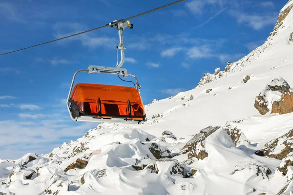 Remontées mécaniques sur les collines station d'hiver de montagne alpine par une journée ensoleillée. Téléski télésiège téléphérique avec les gens aiment le ski et le snowboard. pentes de descente et neige vierge hors piste — Photo