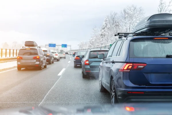 Vinterväg med många olika bilar instoppade i trafikstockning på grund av dåliga väderförhållanden. Fordon på våt väg efter kraftig snöstorm och snöstorm på kall vinterdag i Österrike nära gränsen till Tyskland — Stockfoto
