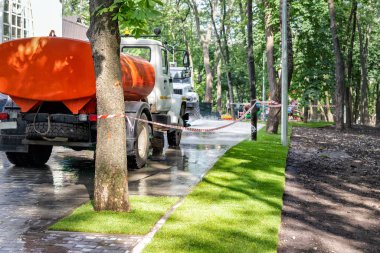 Güneşli bir günde şehir parkında ya da arka bahçede kurulması için hazırlanan toprak toprakla yeni inşa edilmiş yeşil çimen sınırının düz çizgi sınırı. Su tankı su arıtma tesisi